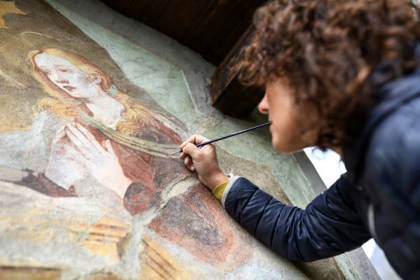 professional restorer restoring antique chapel fresco in italy - restoring art painting artist imagens e fotografias de stock