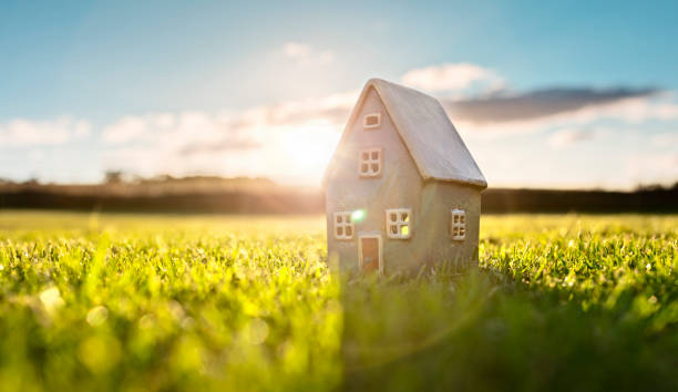 istock Model detatched cottage house in empty field at sunset background concept for construction and real estate 1433155074