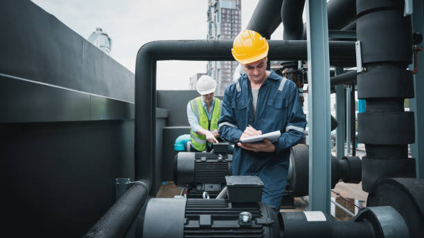 istock Engineer and team examining the air conditioning cooling system of a huge building or industrial site. 1433159977