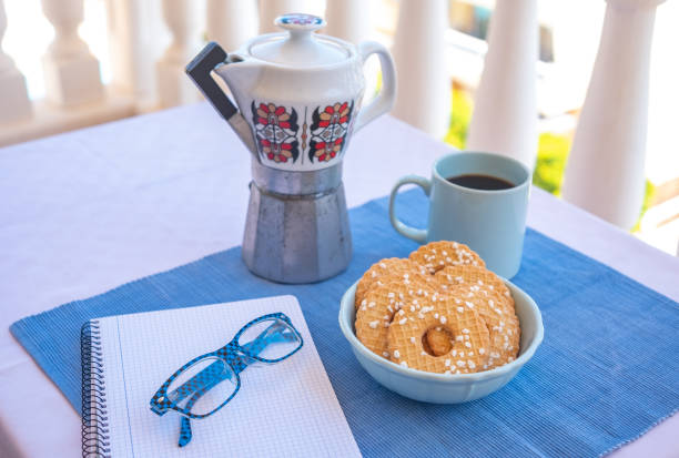 istock Breakfast or break outdoor on a white table with coffe cup and whole grain biscuits. Vintage ceramic coffee maker. 1433160333