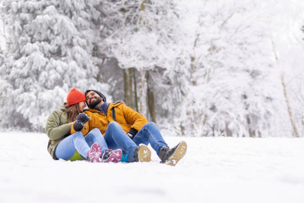 istock Couple hugging in the snow while taking a sliding break 1433161268