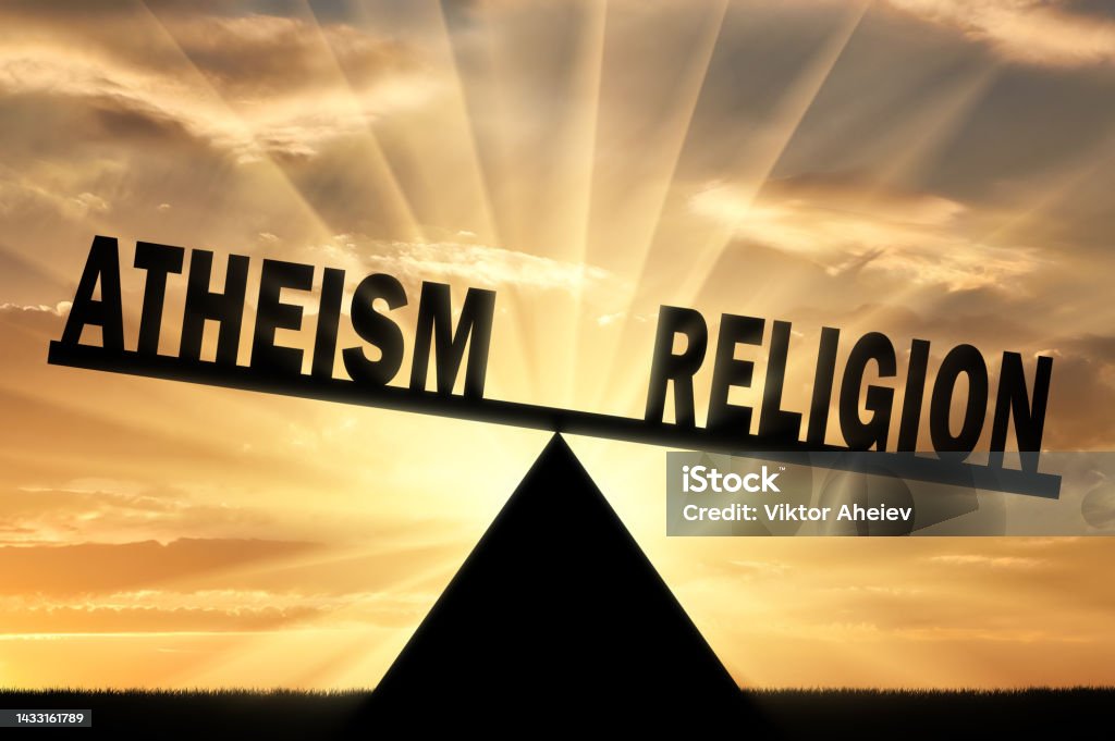 Word religion is more powerful than the word atheism on the scales Word religion is more powerful than the word atheism on the scales. Conceptual image of religion Atheism Stock Photo