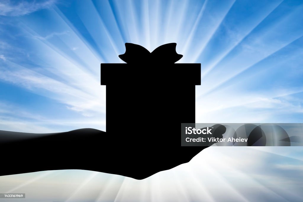 Altruism. Silhouette of a hand giving a gift Altruism concept. Silhouette of a hand giving a gift Selfless Stock Photo