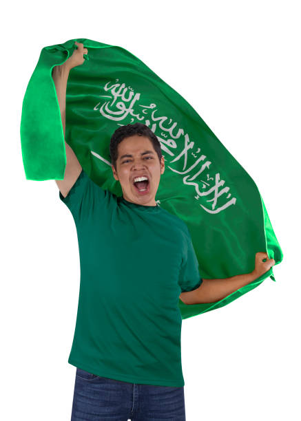 Soccer fan with the flag of his country Saudi Arabia and jersey shouting with emotion for the victory of his team on a white background.