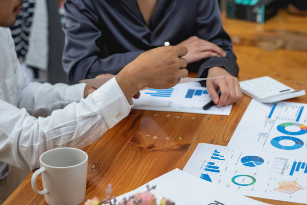 istock The company's team of marketers analyzes the company's profits using laptop computer graphs and calculators. 1433168251