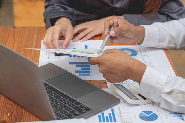 istock Two male and female marketers use company documents and use laptop computers to record data to analyze company profits. 1433168458