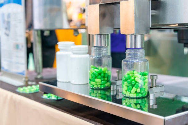 istock close up transparent plastic bottle under nozzle dispenser component of automatic medicine capsule bottle filling and counting machine during manufacturing process 1433168471