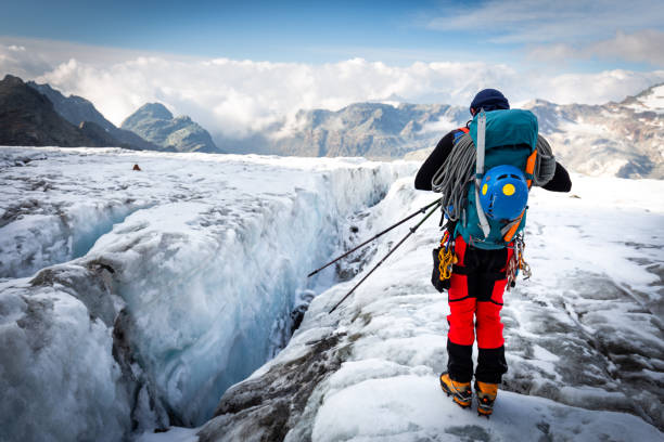alpinista in piedi ghiacciaio sopra la vista della cresta delle montagne del crepaccio - crevasse foto e immagini stock