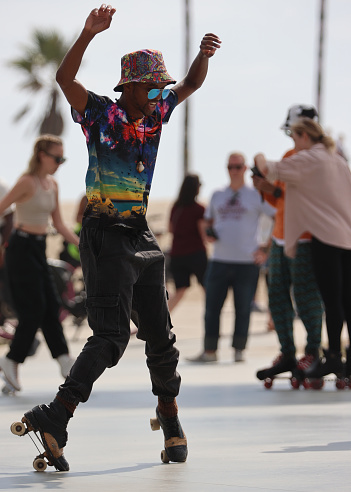 Man roller skating With Arms Raised outdoors at Venice Beach Skate Park in California