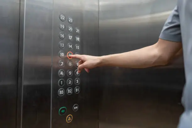 Photo of One hand pressing the elevator floor button