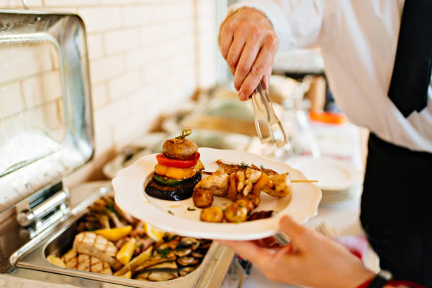 istock the waiter puts fried fish and vegetables from Chafing Dish on a plate. 1433173218