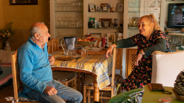 Couple of two old people having a funny talk after a meal stock photo
