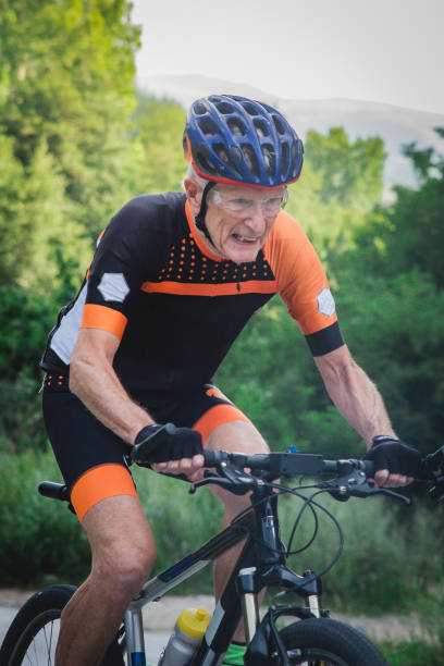 istock Man in his 80's cycling in the mountains 1433186964