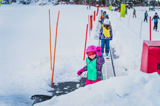 Young skier, girl going up on ski conveyor. Ski winter holidays in Andorra stock photo