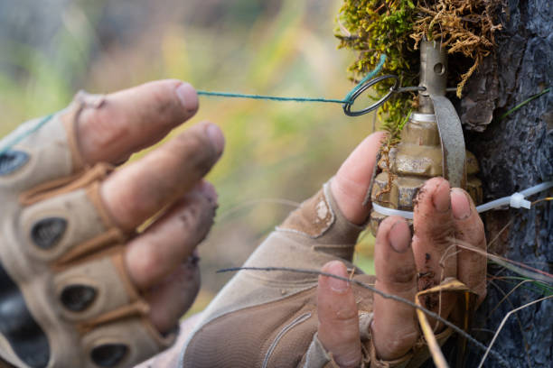istock Installation of a fragmentation grenade - trapwire on a tree. A trap for dealing damage to enemy infantry. Guerrilla war. 1433186989