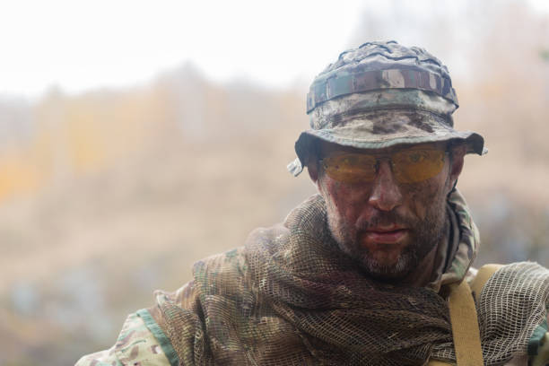 Portrait of a tired soldier with a dirty face. He looking at camera. stock photo