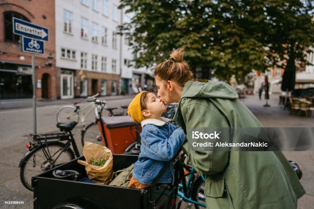 Mom, I love you! Photo of a mother and her son sharing their love and affection towards each other while riding the cargo bike and running errands around the city. Lifestyles Stock Photo