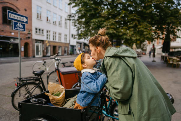 Mom, I love you! Photo of a mother and her son sharing their love and affection towards each other while riding the cargo bike and running errands around the city. scandinavian ethnicity stock pictures, royalty-free photos & images