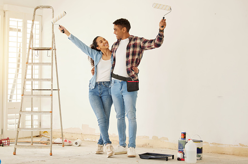 Couple painting room for interior house renovation and home or property design project with smile, white wall background mockup. New home or apartment and happy painter people with DIY hardware