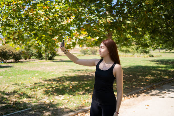 istock Young woman taking selfie in the park while exercising 1433189080