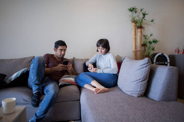 istock couple using the cell phone in the living room 1433190310