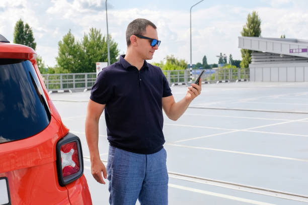 istock Man using phone while standing near his car outdoors. Urban lifestyle 1433191878