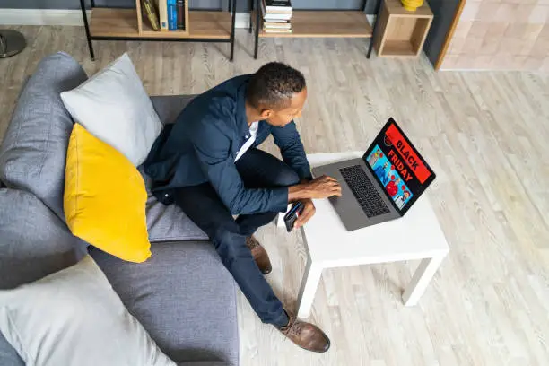 Photo of Man shopping on Black Friday with a laptop compute