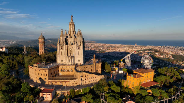 montaña del tibidabo, horizonte de la ciudad de barcelona con el templo sagrat cor al atardecer. cataluña, españa - cathedral church monument religion fotografías e imágenes de stock