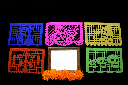 Decorative objects for the altar of the Day of the Dead make a frame for phrases, banners, invitations and posts with cempasuchil portraits and traditional papel picado