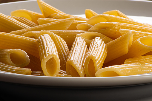 Penne noodles, served in butter, on a white plate