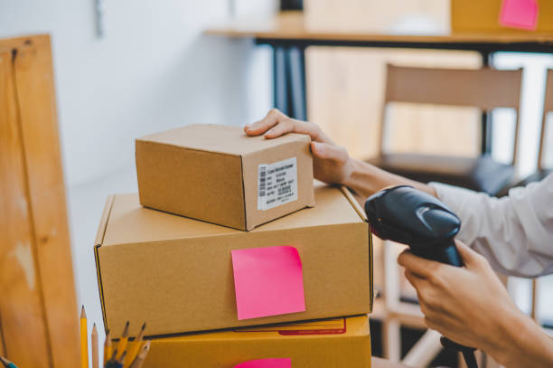 istock Small business owners online are scanning barcode-labelled parcel boxes with a barcode scanner to verify their product orders. of online retailers - online shopping 1433195730