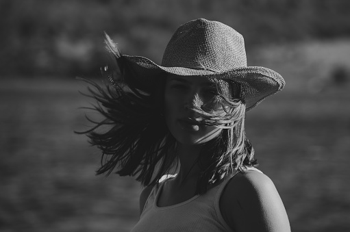 cowboy girl with hat looking at the camera on a sunny day