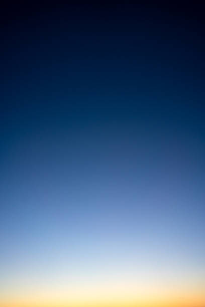 Above the horizon at dusk Photograph of a clear evening sky, just after sunset, with a smooth gradient from black down to golden yellow/orange. dark blue sky stock pictures, royalty-free photos & images