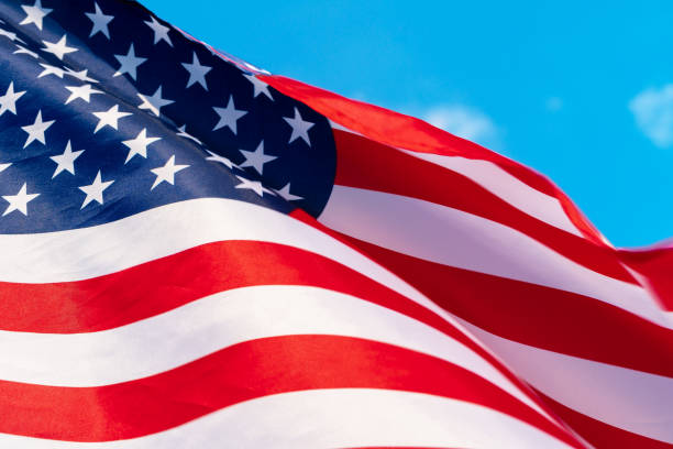 istock American flag waving in the wind against blue sky 1433197326