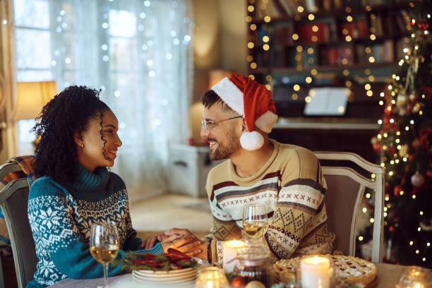 istock Young couple in love talking during Christmas lunch at dining table. 1433199542