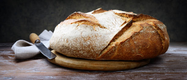 istock Traditional bread, knife and cutting board on floured pastry board, close-up. 1433199846