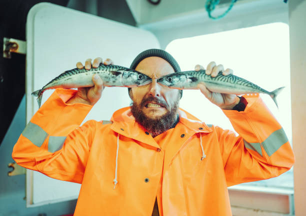 fischer mit fisch vor den augen - bizarre making a face men one person stock-fotos und bilder