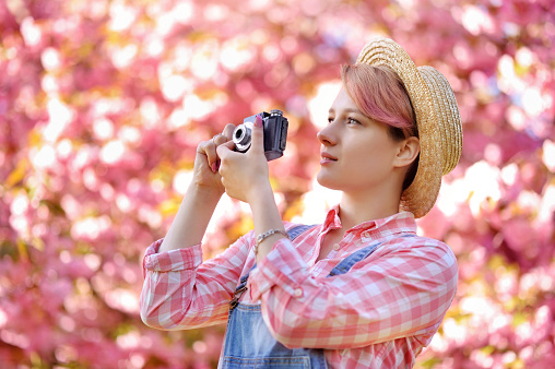 Side view portrait of a girl photographer in a straw hat