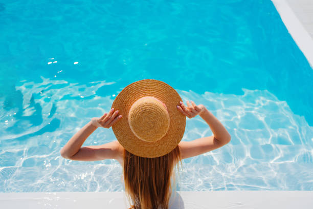 istock top view. a woman in a straw hat in the pool. 1433205174