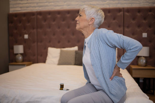 istock Senior woman with back pain sitting on couch 1433206543