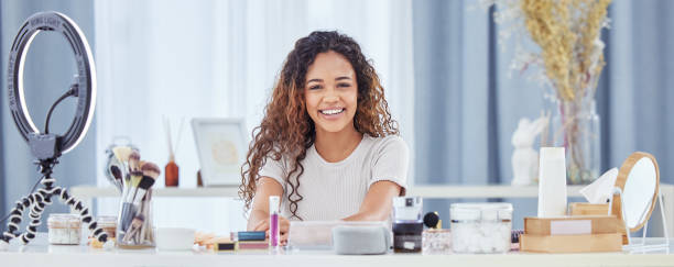 istock One hispanic woman recording a makeup tutorial for her beauty blog with her phone while sitting at home. African american female influencer live streaming her cosmetic review and recommendation online 1433209113
