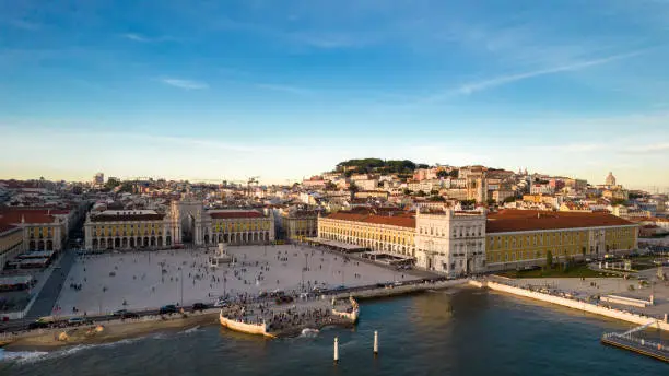 Photo of Aerial view of pedestrians at Praca do Comercio in Lisbon, Portugal with St. George Castle in the background as well as other Lisbon landmarks