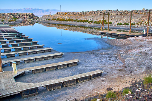 Boat docks sitting on mud flats in an unusable marina due to receding water levels at Great Salt Lake State Park, Utah in 2021.