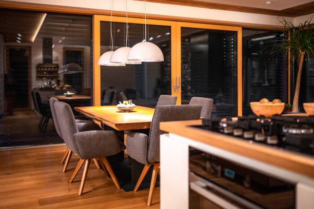 Kitchen with table and padded design chairs in evening
