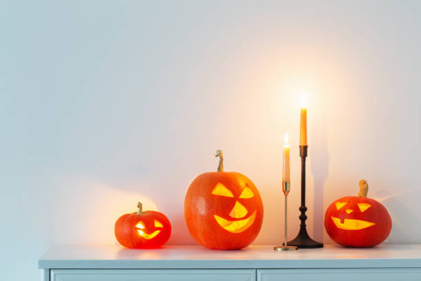 istock halloween pumpkins with burning candles in white interior 1433225320