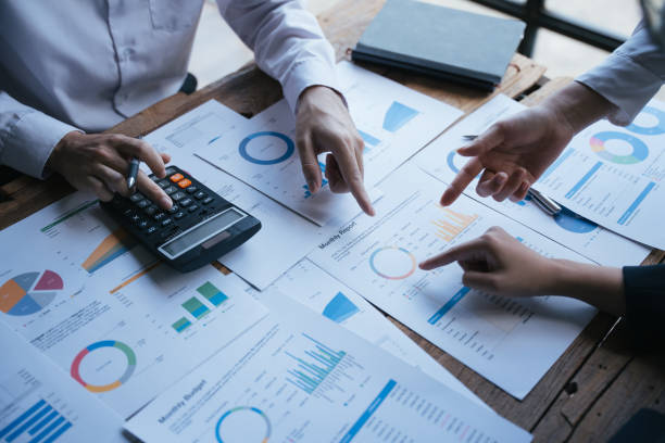 istock Team working on business project at messy table with graph chart and financial reports, calculator,presentation the new finance project plan at meeting, businessteam discussing and planning concept. 1433233301