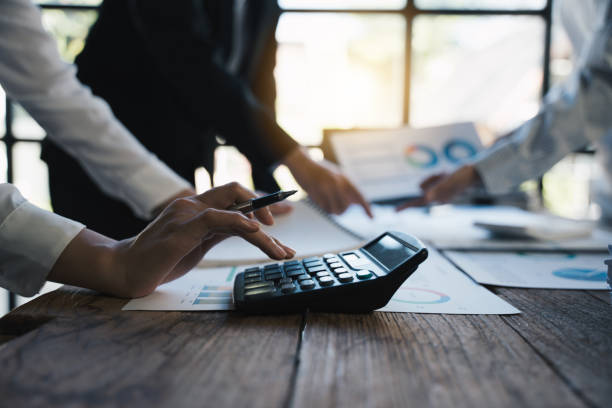 istock Team working on business project at messy table with graph chart and financial reports, calculator,presentation the new finance project plan at meeting, businessteam discussing and planning concept. 1433235520