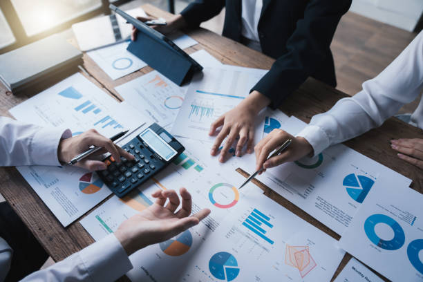 istock Team working on business project at messy table with graph chart and financial reports, calculator,presentation the new finance project plan at meeting, businessteam discussing and planning concept. 1433235886