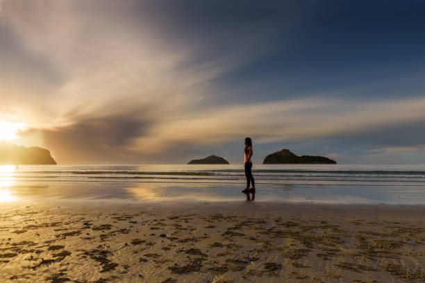 istock A woman watching sunrise alone on the beach 1433252217