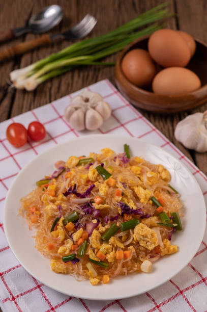istock Stir fried glass noodles with eggs and put on a plate on a red white cloth. 1433255995